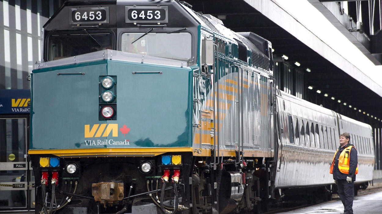 Un cheminot regarde une locomotive de VIA Rail.