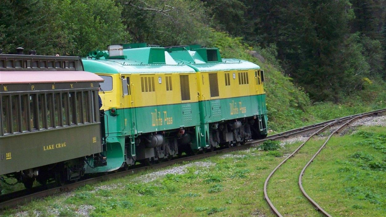 Une locomotive d'un train touristique tire des wagons vers le col de White Pass