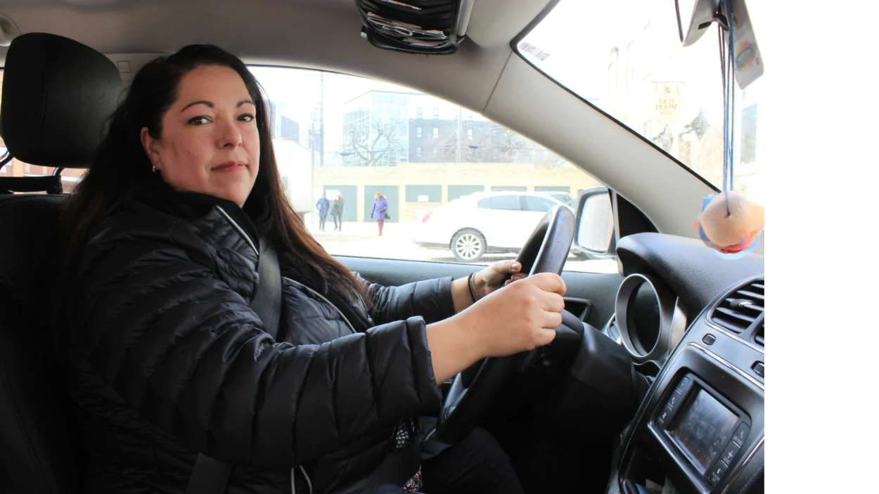 Une femme au volant d'une voiture.