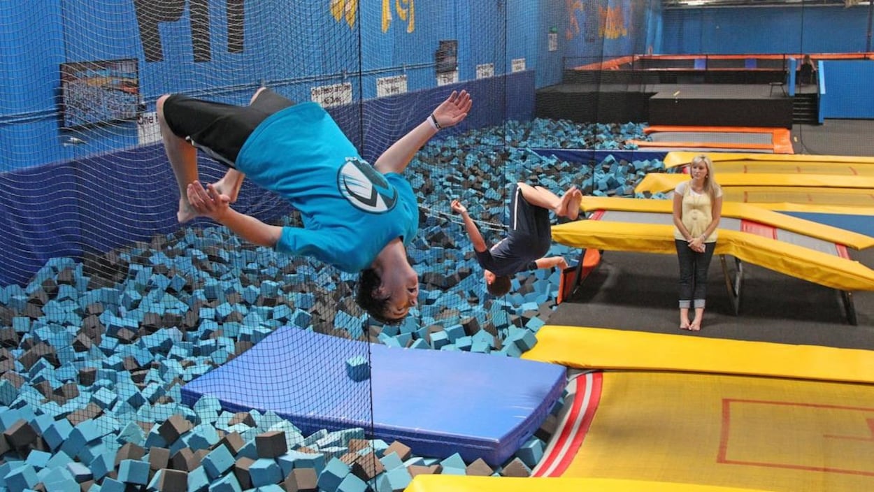 Un homme fait un saut dans un centre de trampoline.