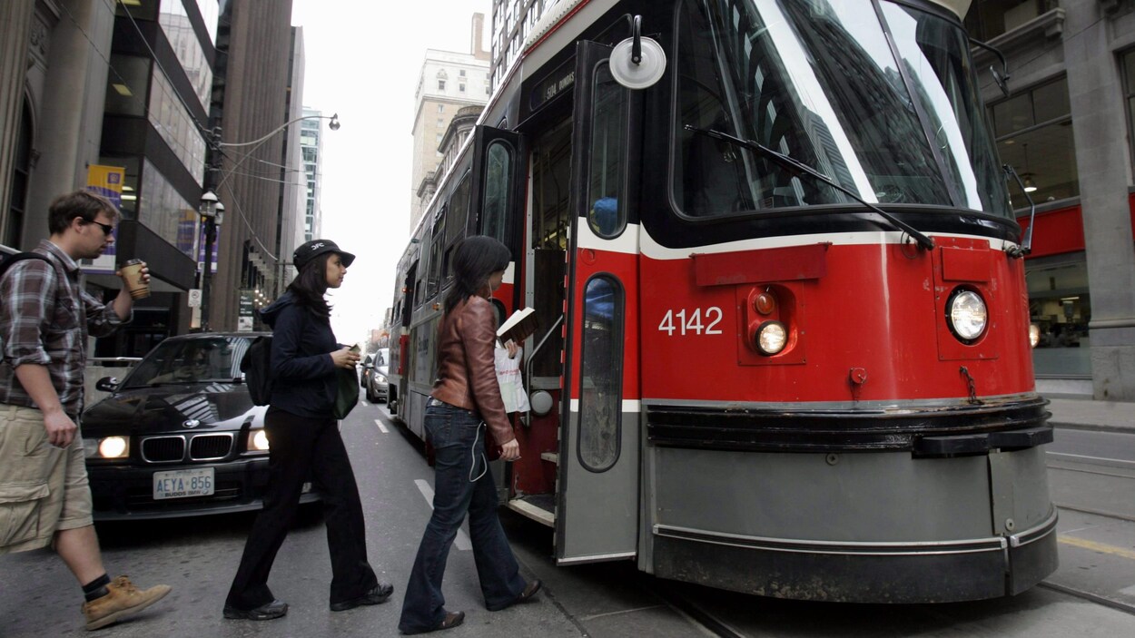 Des passagers montent à bord du tramway 504 au centre-ville de Toronto