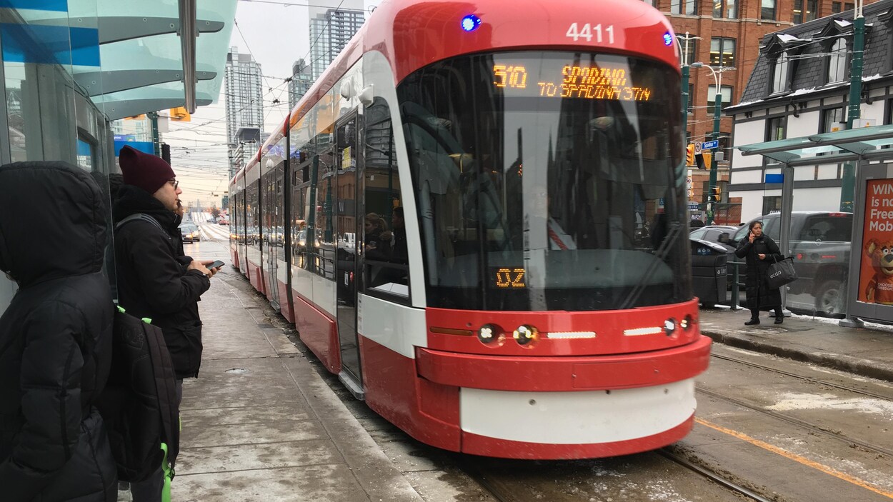 Photo d'usagers qui attendent à un arrêt de tramway. Photo d'usagers qui attendent à un arrêt de tramway.