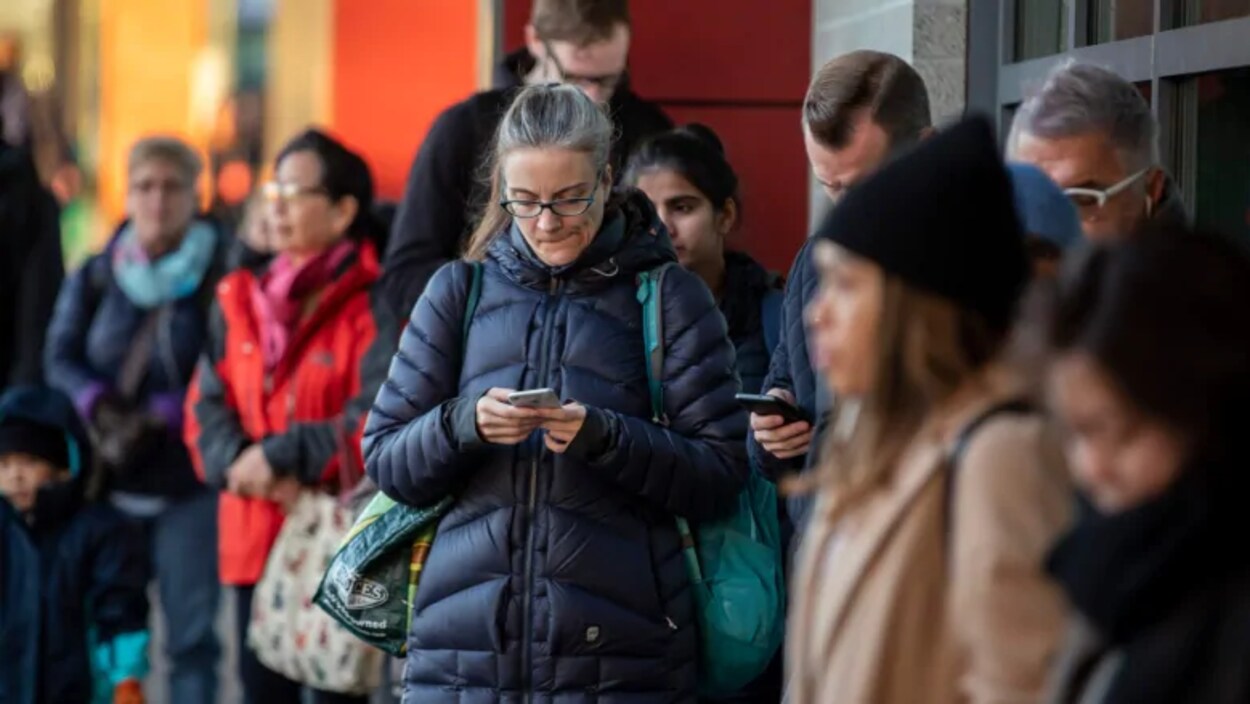 Des personnes font la file en attendant leur moyen de transport.