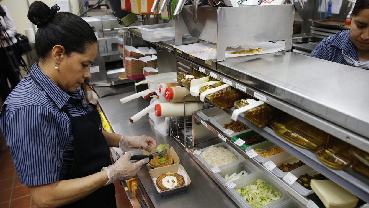Une travailleuse s'affaire dans un restaurant.