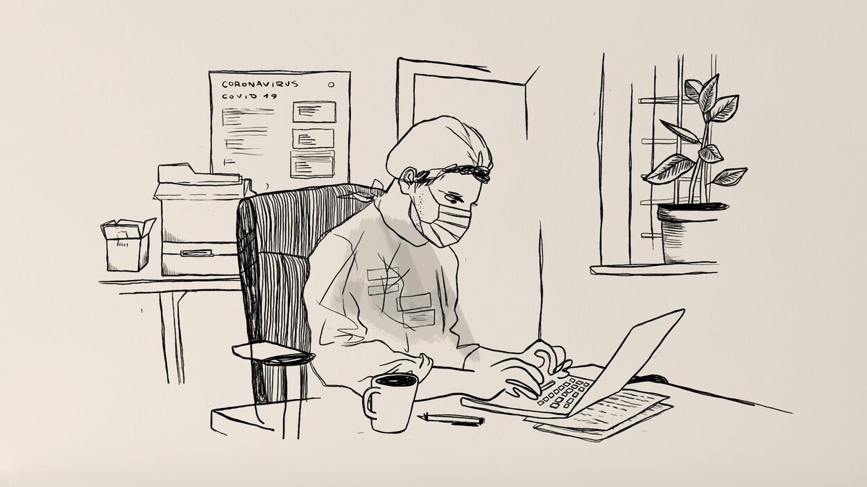 Assis à son bureau, un homme portant un masque écrit à son ordinateur