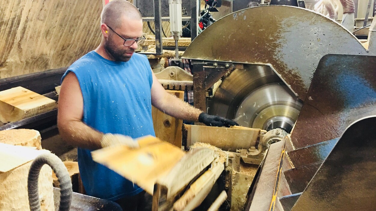 Un travailleur de la scierie Waska, au Nouveau-Brunwick, coupe des bardeaux de cèdre.