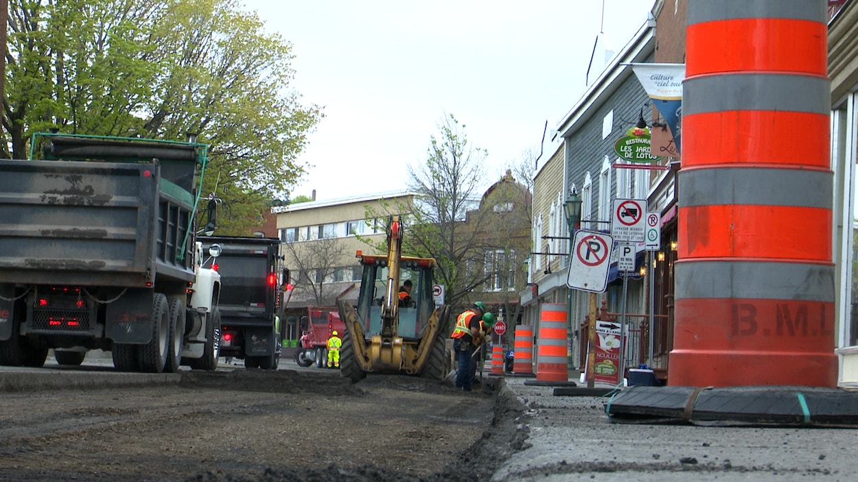 Travaux d'asphaltage et cônes orange.
