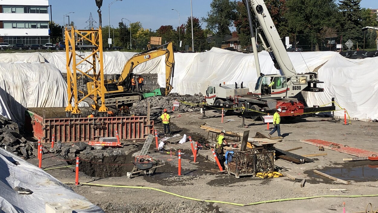 De la machinerie et des travailleurs sur un chantier de construction.