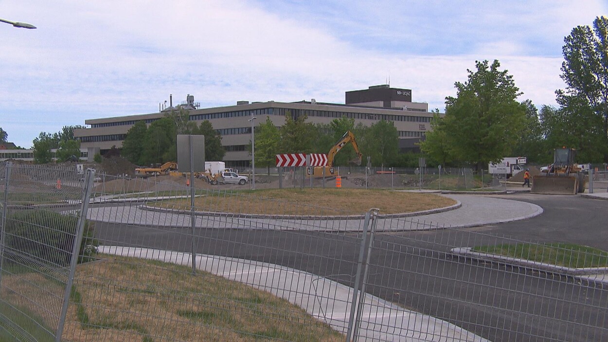 Un carrefour giratoire et des pelles mécaniques devant l'UQAC