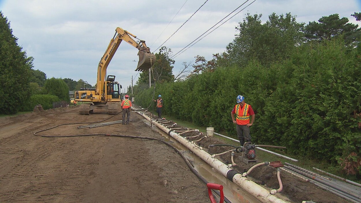 Des tracteur et travailleurs s'affèrent sur le chantier d'assainissement.
