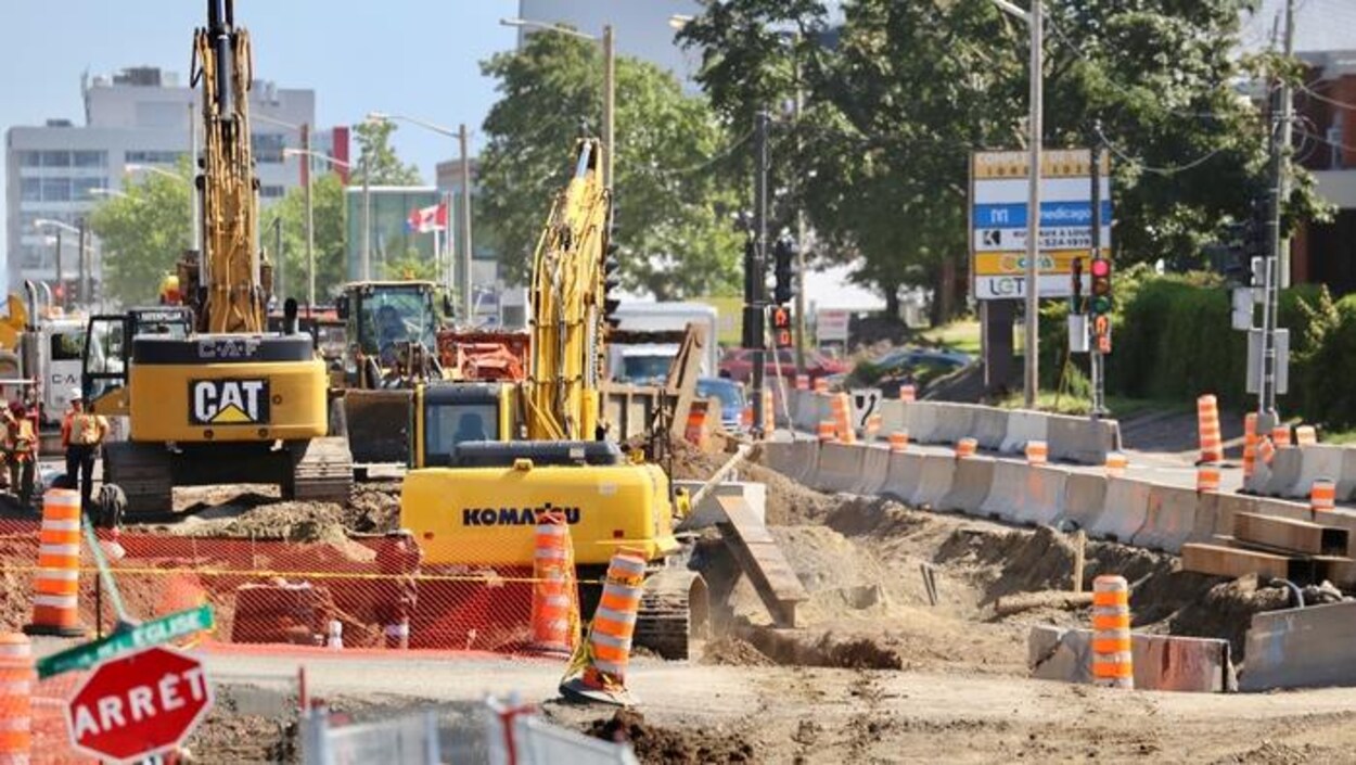 De la machinerie lourde dans un chantier de construction en été.
