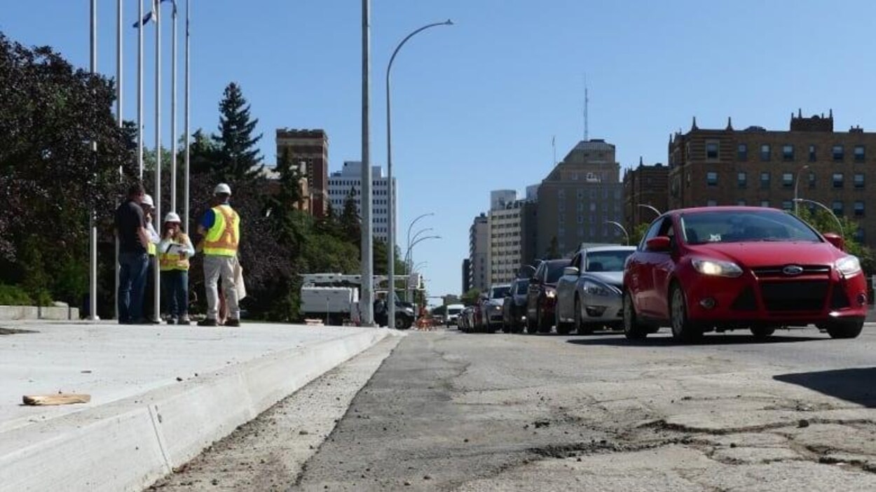 Des voitures sont prises dans un embouteillage dans une rue en réparation.