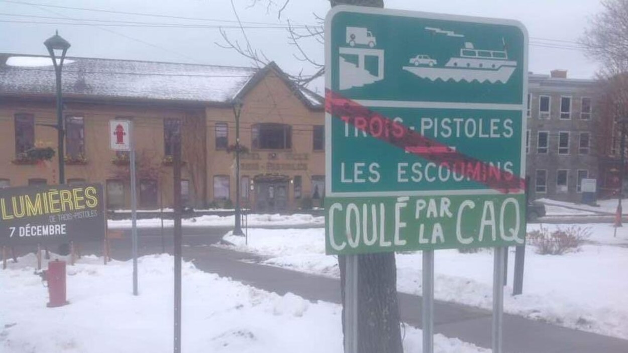 Une ligne rouge est tracée sur la pancarte de la traverse Trois-Pistoles - Les Escoumins pour signifier que la traverse ne sera plus accessible. En bas, un bout d'affiche a été ajouté avec l'inscription : coulé par la CAQ.