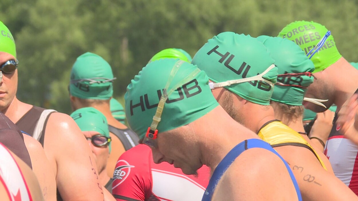 Plusieurs hommes au départ d'un triathlon