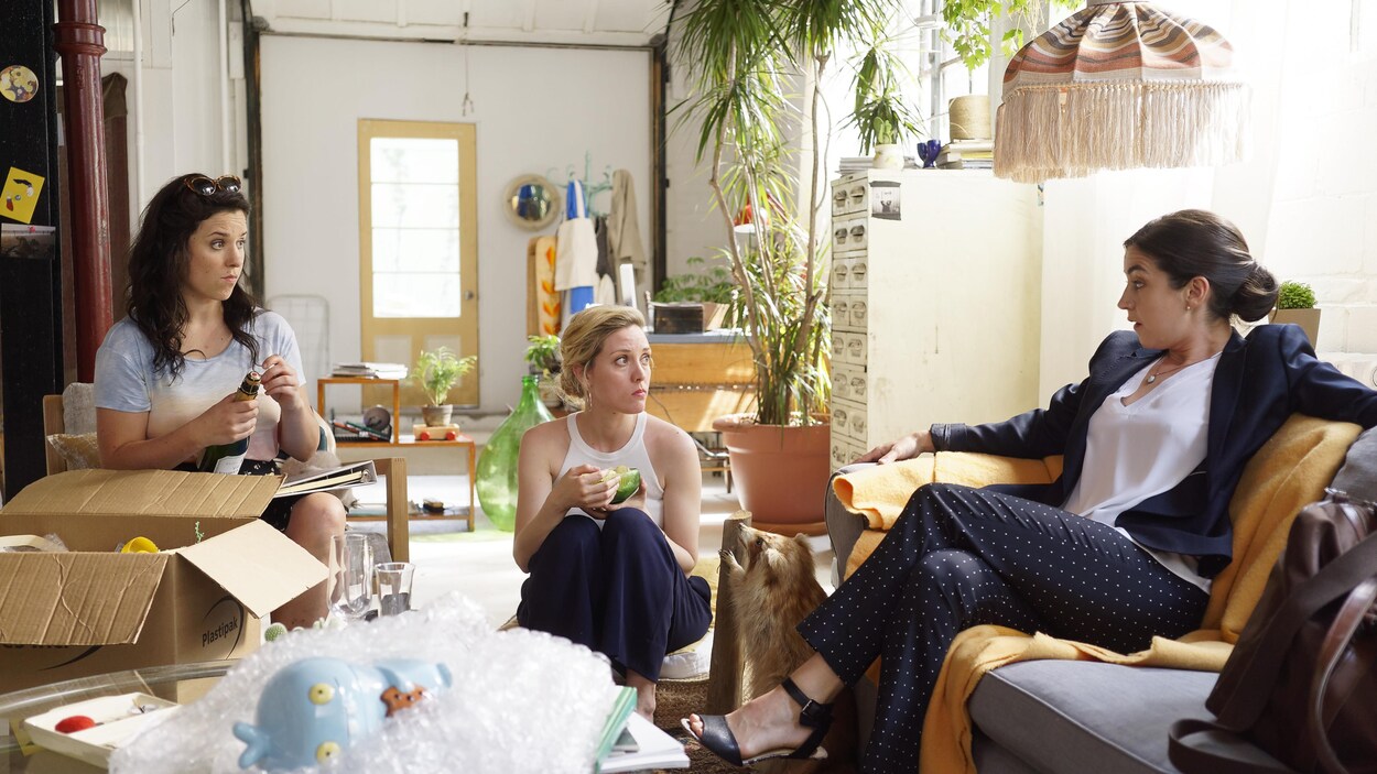 De gauche à droite : Virginie Fortin, Evelyne Brochu et Alice Pascual discutent, assises dans le salon, dans la websérie « Trop ».