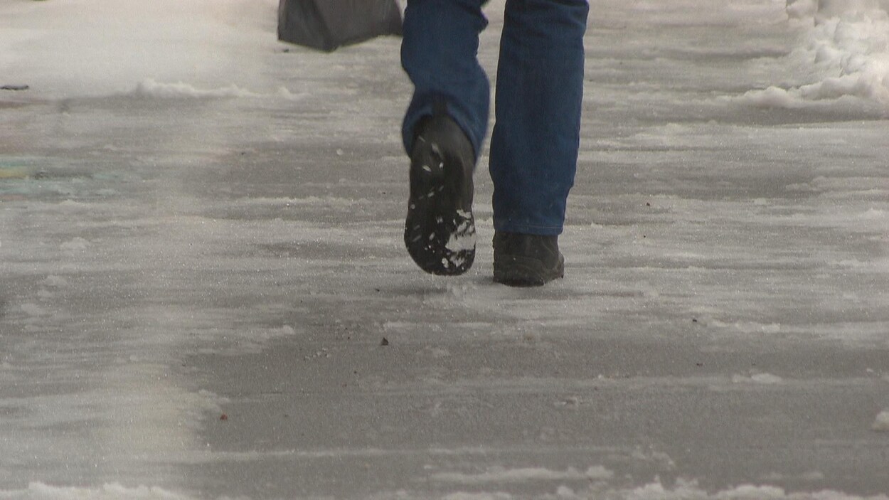 Pieds d'une personne qui marche sur un trottoir glacé Pieds d'une personne qui marche sur un trottoir glacé