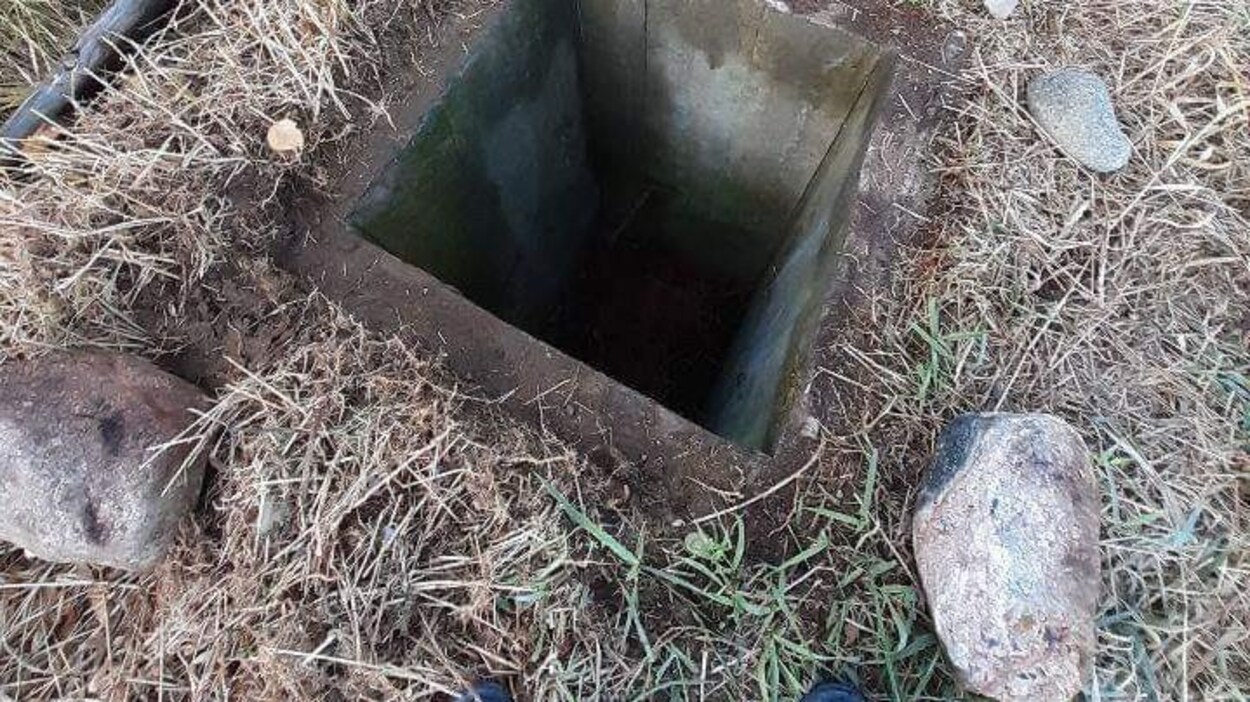 Un trou de forme carrée sur un terrain de paille.