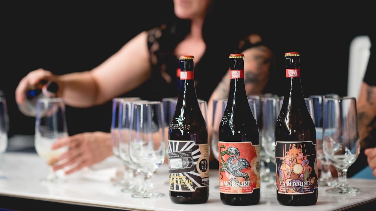 Une femme en train de verser des bières de la microbrasserie Le trou du diable. Une femme en train de verser des bières de la microbrasserie Le trou du diable.