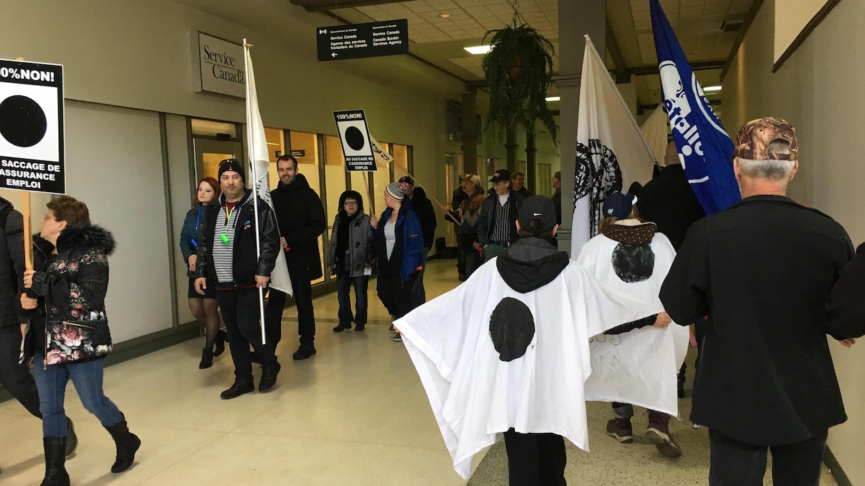 Des manifestants devant les bureaux de Services Canada à Baie-Comeau dans un centre commercial Des manifestants devant les bureaux de Services Canada à Baie-Comeau dans un centre commercial