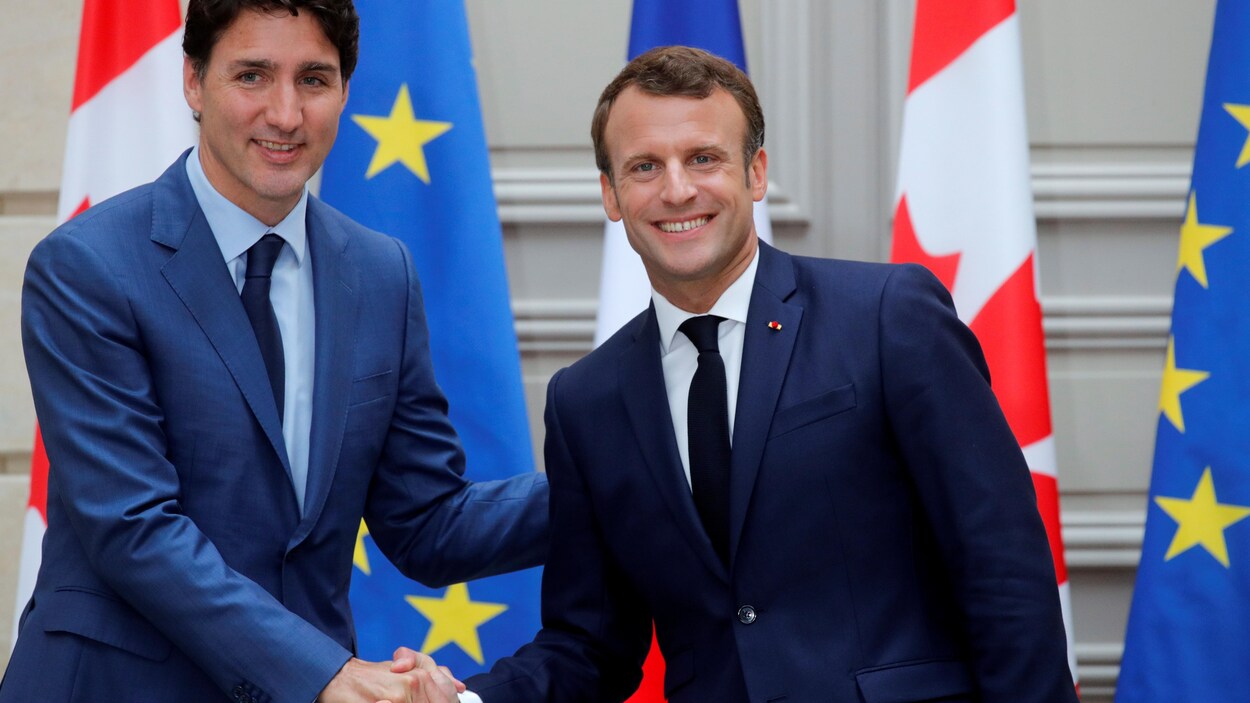 Justin Trudeau serre la main d'Emmanuel Macron.