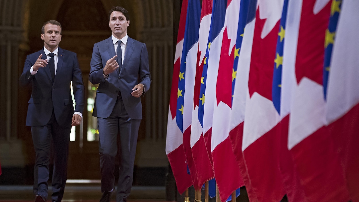 Emmanuel Macron et Justin Trudeau discutent en marchant.