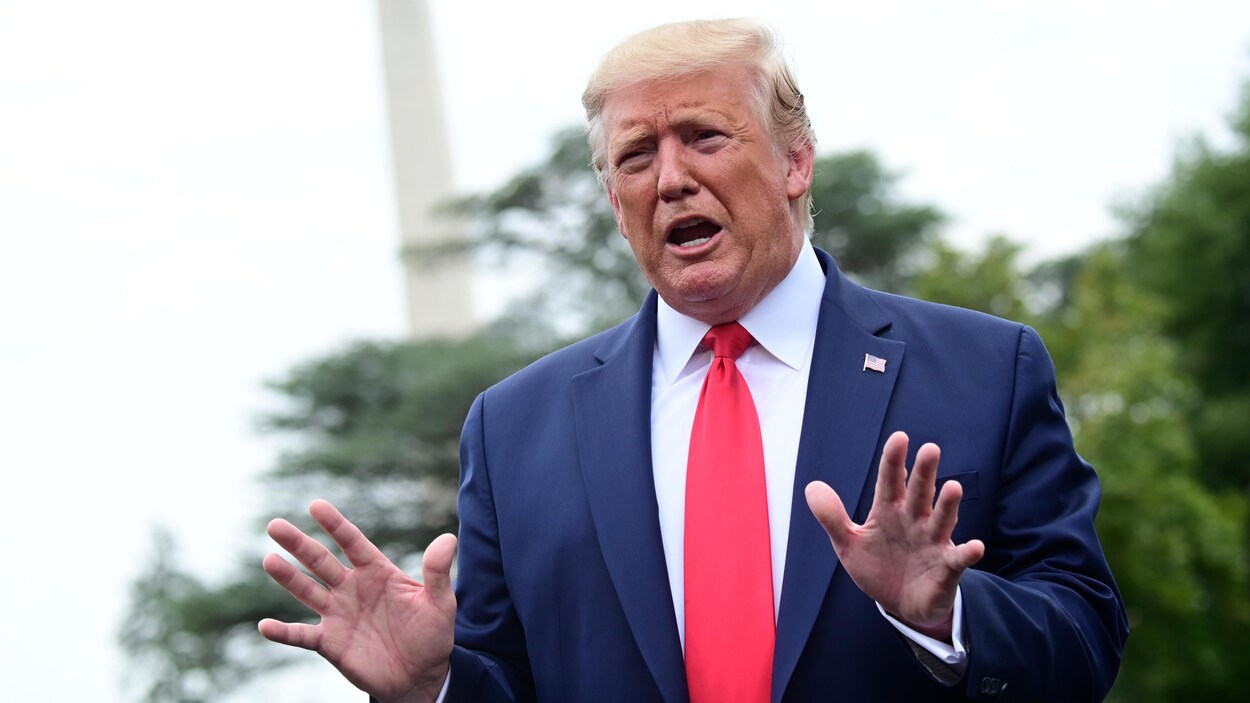 Plan moyen de M. Trump qui parle en levant les mains.