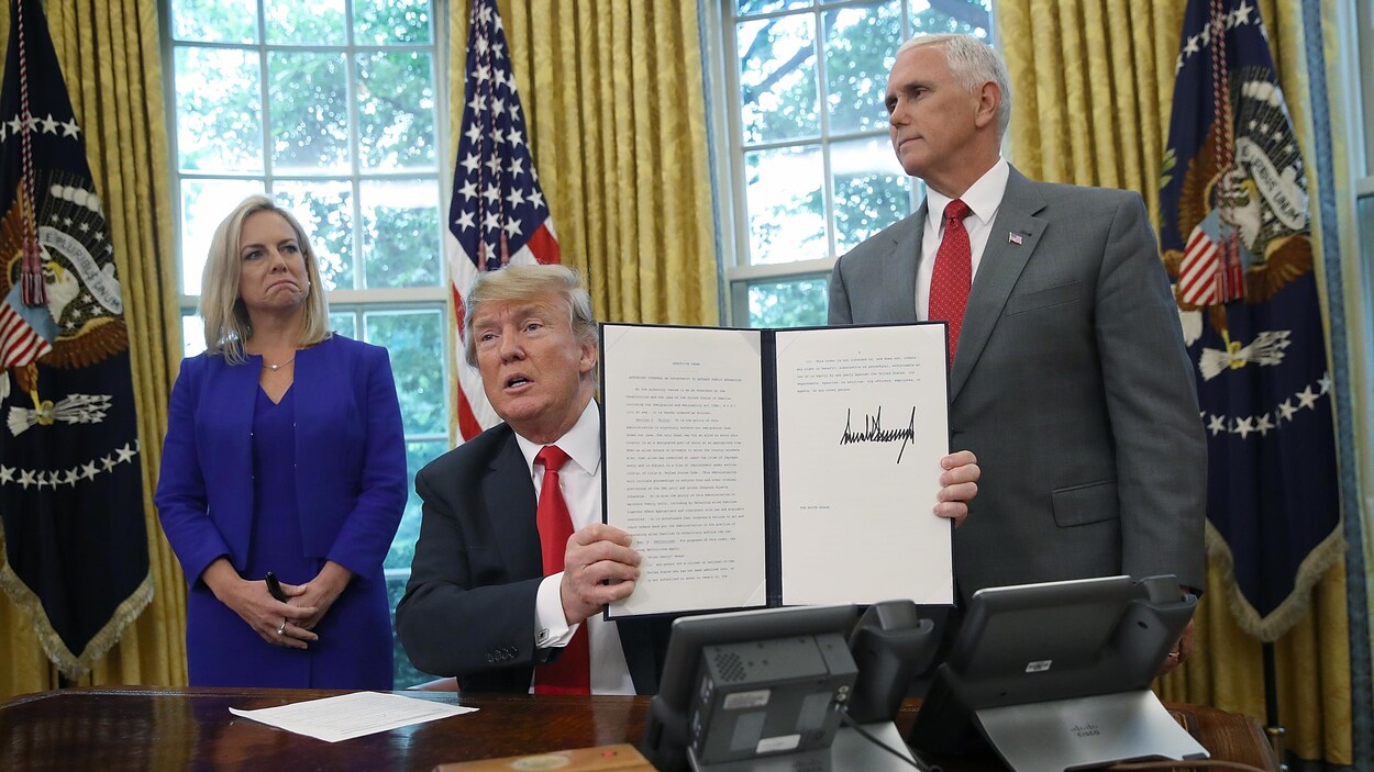 Le président américain Donald Trump signe le décret avec, derrière lui, la secrétaire à la Sécurité intérieure Kirstjen Nielsen et le vice-président Mike Pence.