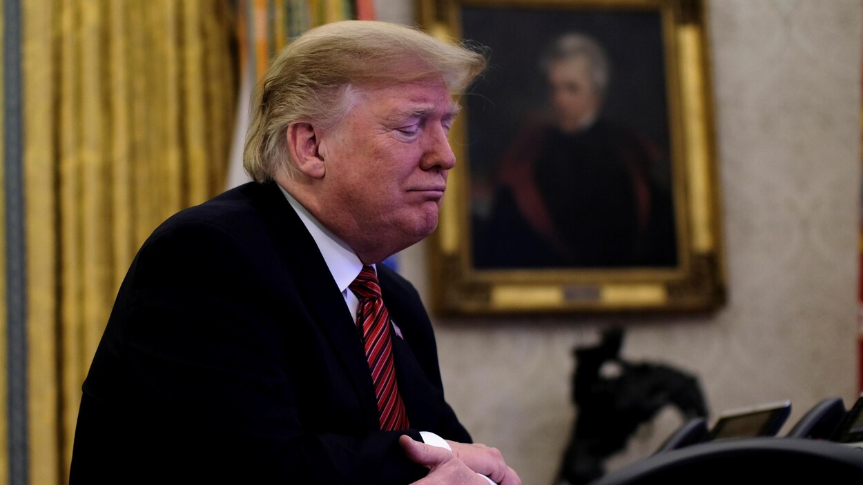 Donald Trump est assis à son bureau dans la Maison-Blanche.