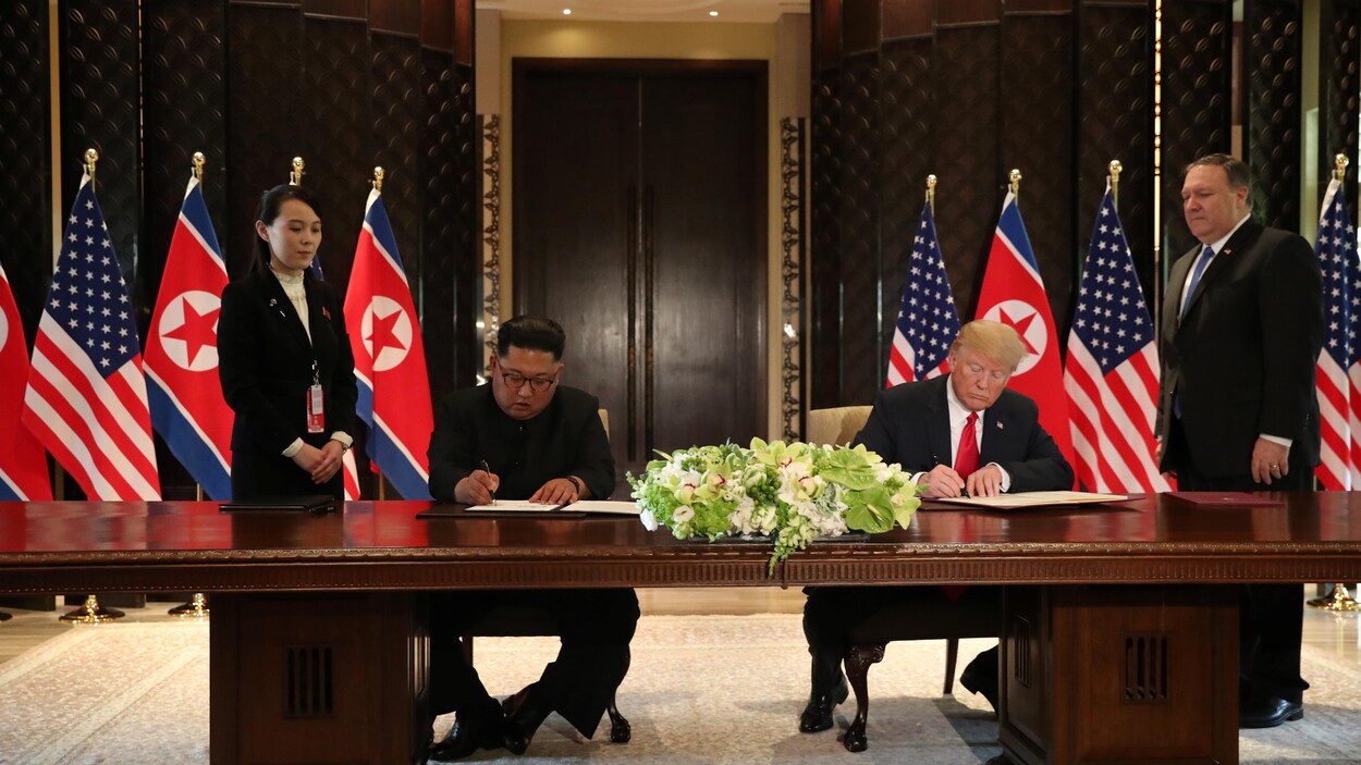 Kim Jong-un et Donald Trump signent un document officiel, entourés de Kim Yo-jong et Mike Pompeo.