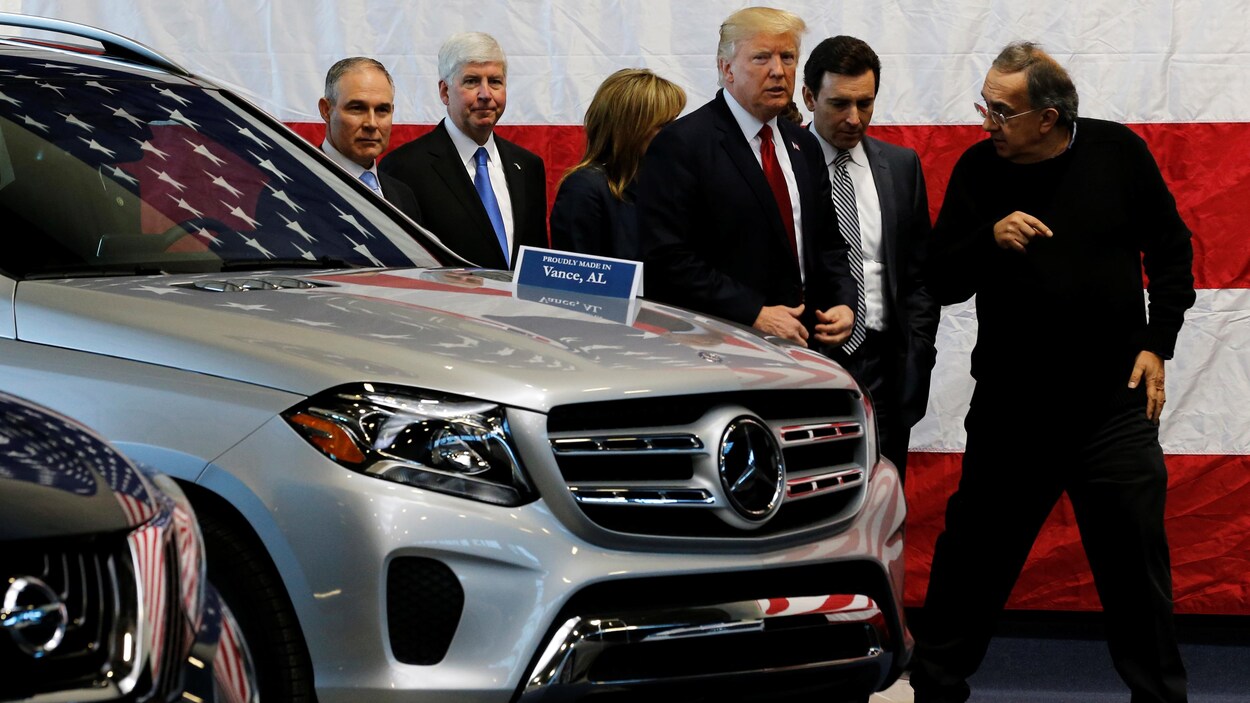 Donald Trump discute avec Sergio Marchionne en contournant un véhicule utilitaire sport. Donald Trump discute avec Sergio Marchionne en contournant un véhicule utilitaire sport.