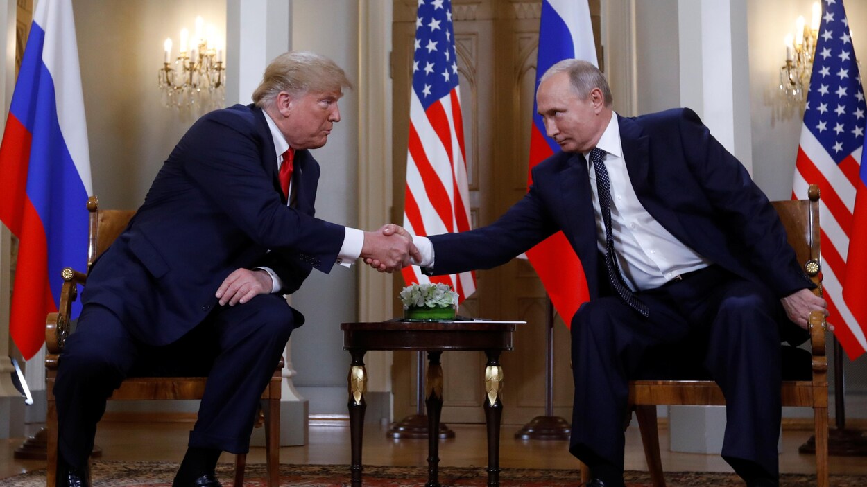 MM. Trump et Poutine se penchent l'un vers l'autre pour se serrer la main.
