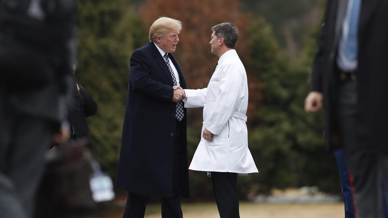 Le président américain Donald Trump et le médecin Ronny Jackson se serre la main.