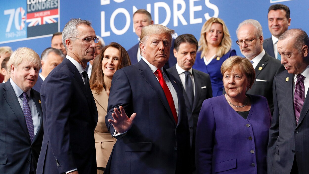 Donald Trump fait un signe de la main en quittant une scène qu'il partageait avec d'autres dirigeants.