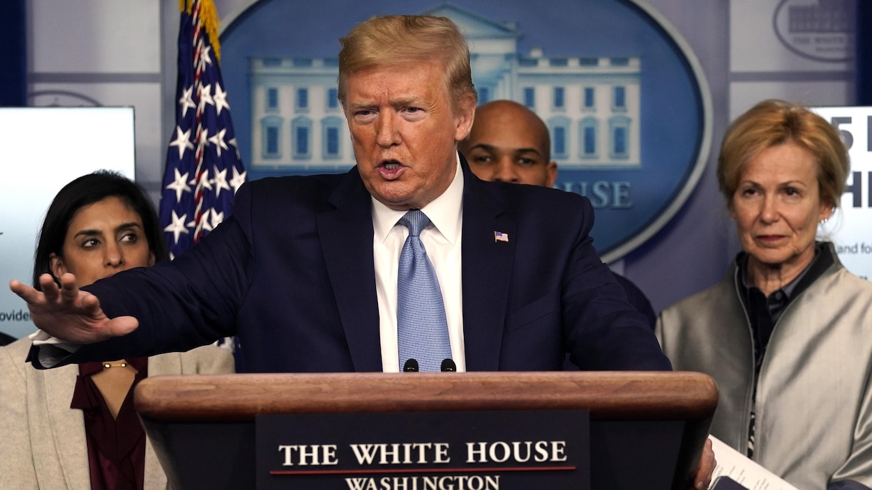 Le président Trump, à l'avant-plan, accompagné de l'équipe responsable de la réponse américaine à l'épidémie, s'adresse aux journalistes.