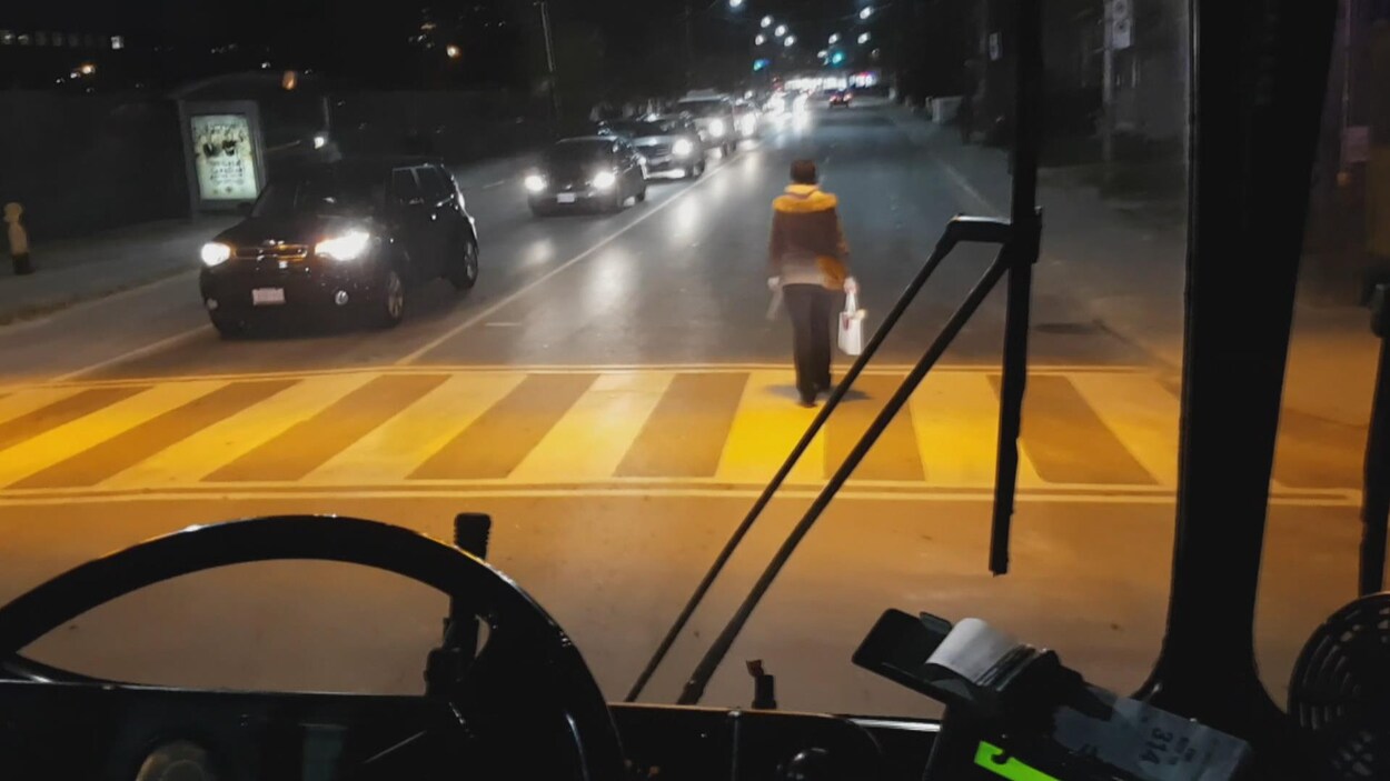 Une femme qui n'a pu monter à bord d'un autobus bondé a manifesté son mécontentement en marchant devant le véhicule. Une femme qui n'a pu monter à bord d'un autobus bondé a manifesté son mécontentement en marchant devant le véhicule.