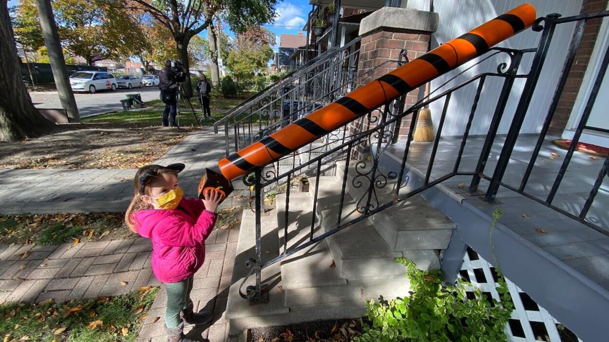 Une petite fille devant un tuyau de PVC orange