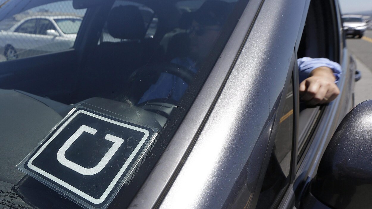 Plan serré d'une étiquette de la compagnie Uber sur le pare-brise d'une voiture.