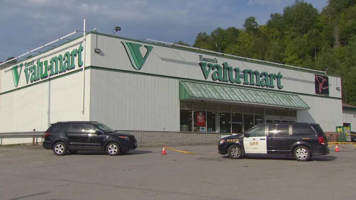 Un véhicule de la Police provinciale de l'Ontario et une voiture devant une épicerie.