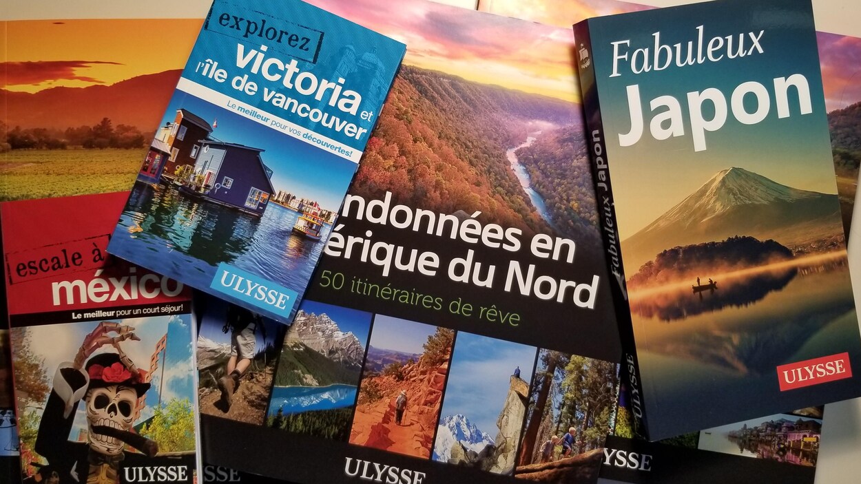 Plusieurs livres posés sur une table, dont des guides pour le Japon, Mexico et l'île Victoria, ainsi qu'un guide des randonnées en Amérique du Nord.