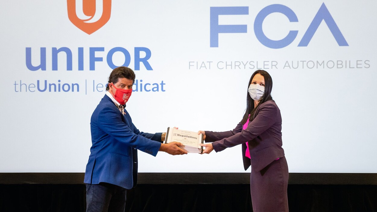 Le président d'Unifor Jerry Dias remet les demandes du syndicat à Jacqueline Oliva de Ford Chrysler Canada mercredi à Toronto.