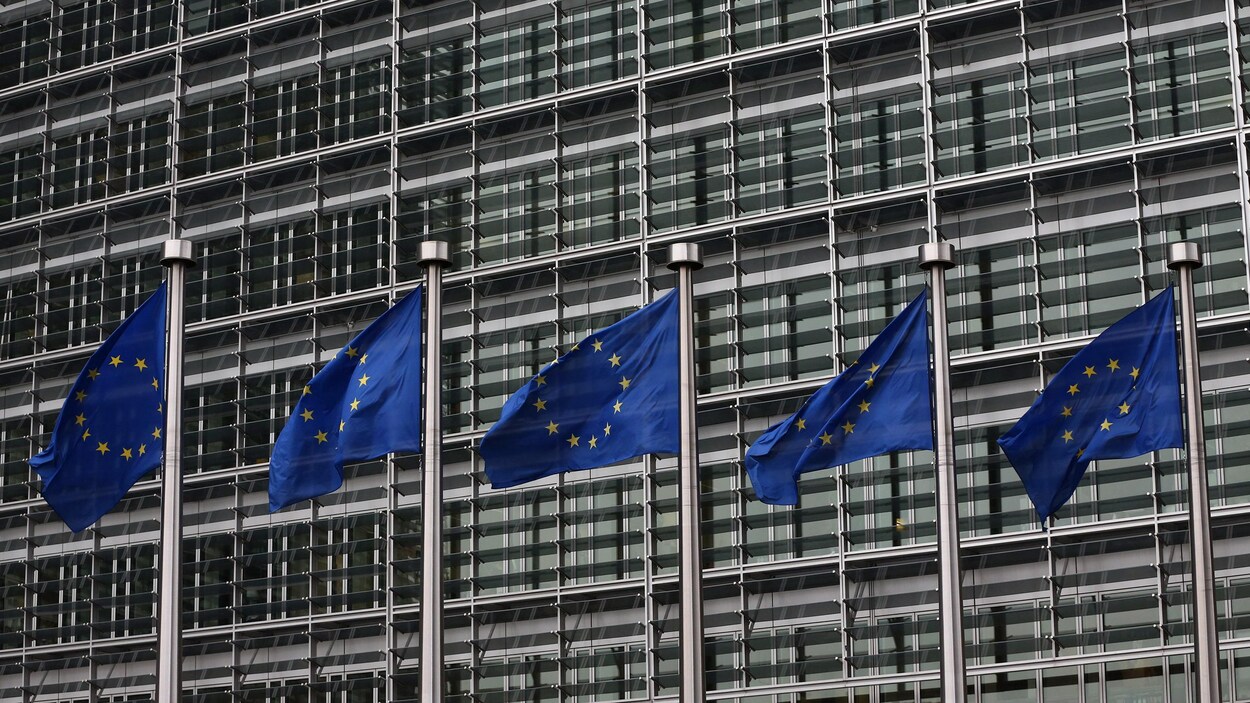 Des drapeaux de l'Union européenne flottent devant un édifice à Bruxelles.