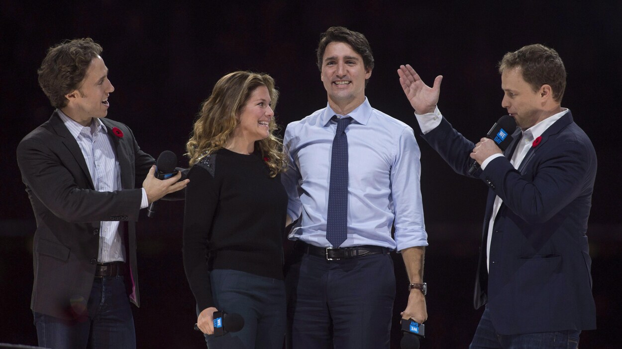 Quatre personnes sur scène lors d'un événement public.