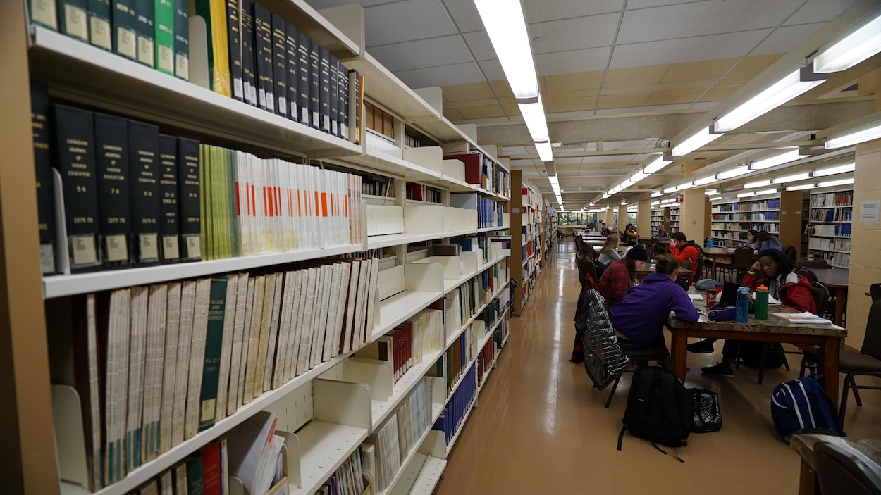 À gauche des livres et au fond des étudiants qui étudient.