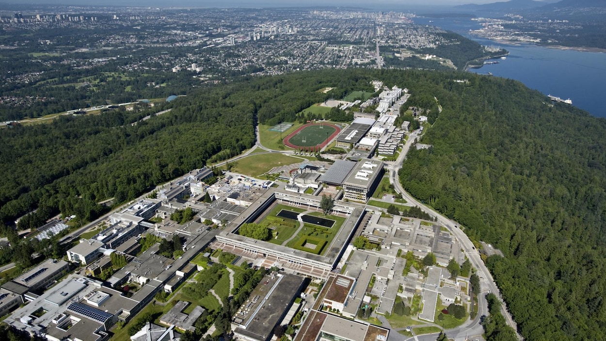 Vue du ciel sur un ensemble de bâtiments entouré d'un grand espace vert.