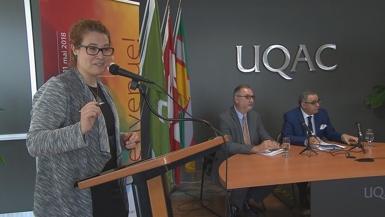 Marie-Karlynn Laflamme au micro et deux autres intervenants assis à une table.