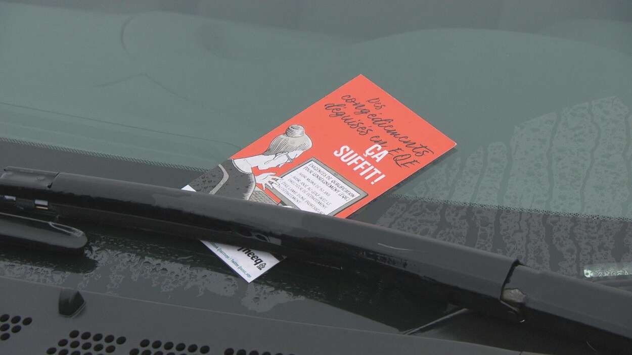 Un tract rouge sur le pare-brise d'une voiture.