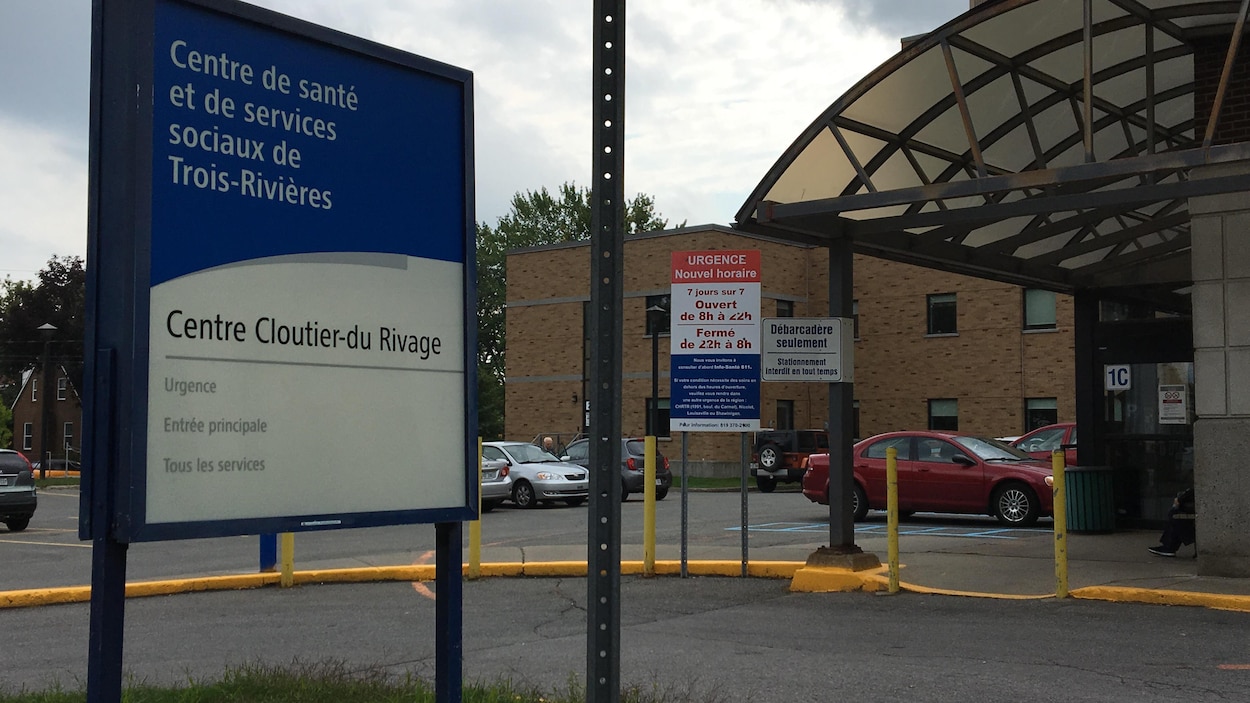 Une pancarte indiquant l'entrée principale du Centre Cloutier-du-Rivage, et une affiche indiquant, en arrière-plan, les heures d'ouvertures réduites.