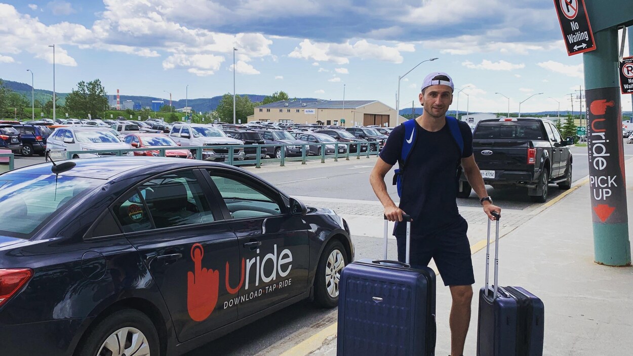 Le PDG de Uride à l'aéroport devant un véhicule Uride.
