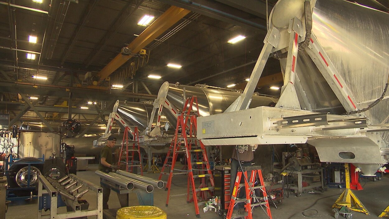 Une usine de fabrication de citernes en aluminium, où on voit des pièces et des ouvriers.