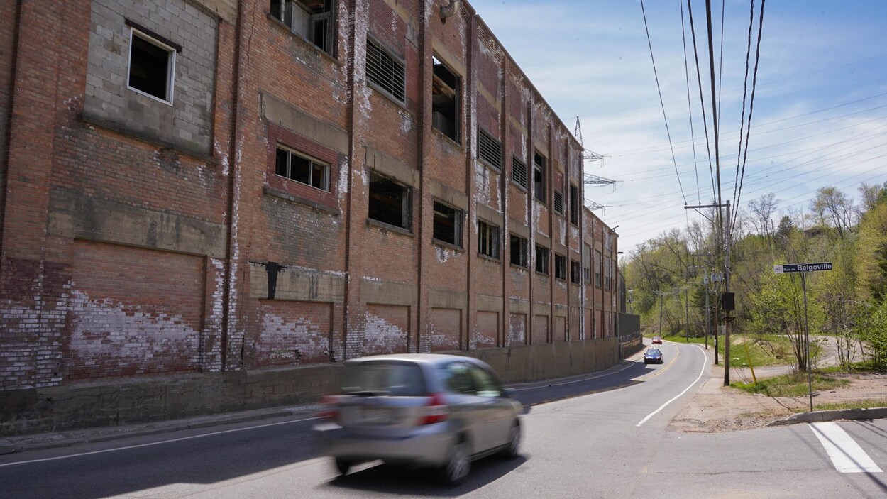 Une usine désaffectée en bordure d'une route.